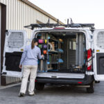 electrician standing next to an organized upfitted van.