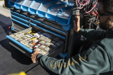 an Adrian Steel drawer unit with some drawers open that contain work supplies